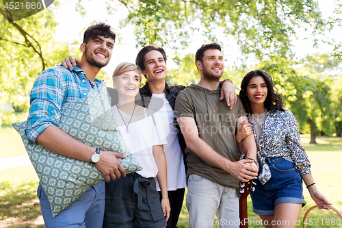 Image of happy friends with guitar at summer park