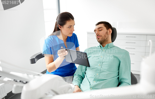 Image of dentist and patient with tablet pc at clinic