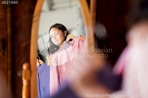 Image of woman with dress at vintage clothing store mirror