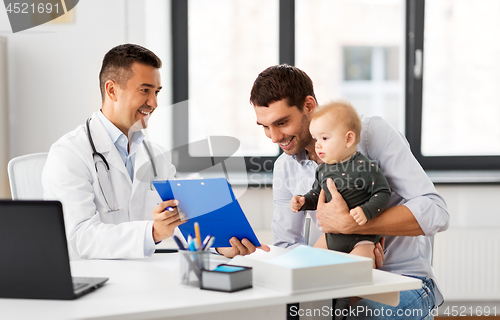 Image of father with baby and doctor at clinic