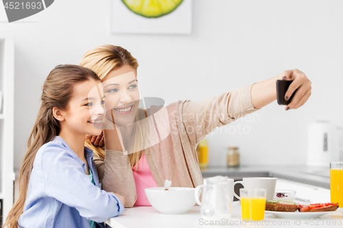 Image of family taking selfie by smartphone at breakfast