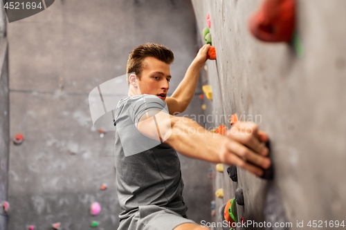 Image of young man exercising at indoor climbing gym