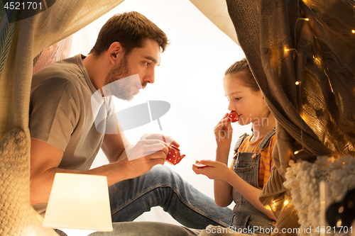 Image of family playing tea party in kids tent at home