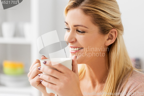 Image of close up of happy woman with coffee cup at home
