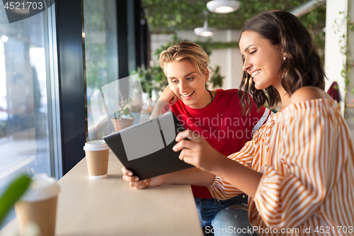 Image of female friends with tablet pc and coffee at cafe