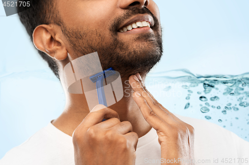 Image of close up of man shaving beard with razor blade