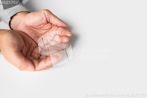 Image of cupped senior man hands on table