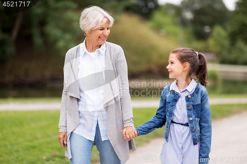 Image of grandmother and granddaughter walking at park