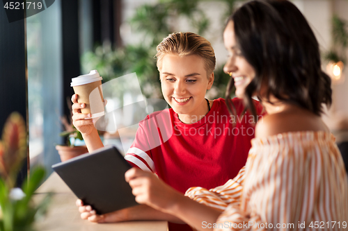 Image of female friends with tablet pc and coffee at cafe