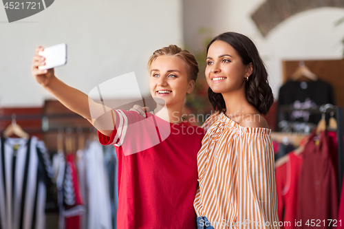 Image of female friends taking selfie at clothing store