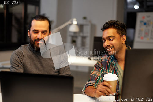 Image of creative team drinking coffee at night office