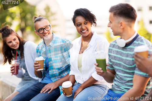 Image of friends drinking coffee and juice talking in city