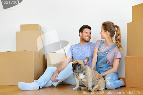 Image of happy couple with boxes and dog moving to new home