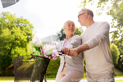 Image of happy senior couple with bicycles at summer park