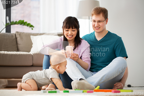 Image of mixed race family with baby son playing at home