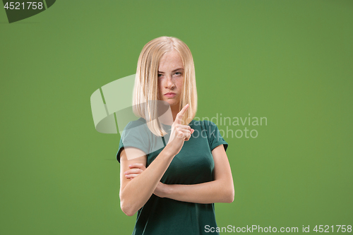 Image of Suspiciont. Doubtful pensive woman with thoughtful expression making choice against green background