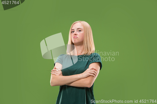 Image of Suspiciont. Doubtful pensive woman with thoughtful expression making choice against green background