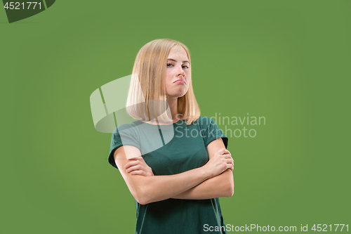 Image of Suspiciont. Doubtful pensive woman with thoughtful expression making choice against green background