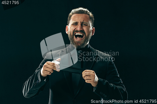 Image of The barded man in a suit at black studio