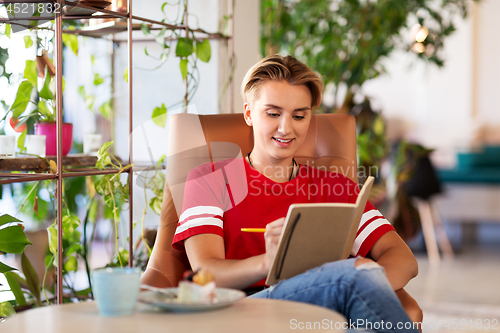 Image of teenage girl with notebook at coffee shop or cafe