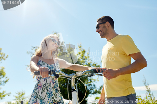 Image of happy couple with bicycle at country