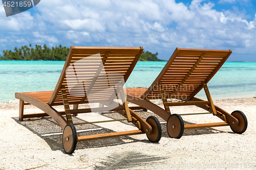 Image of tropical beach with palm tree and sunbeds