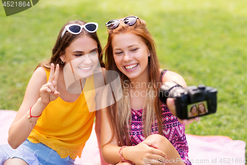 Image of teenage bloggers recording video by camera in park