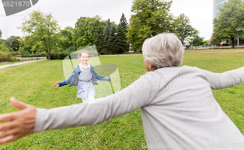 Image of grandmother and granddaughter playing at park