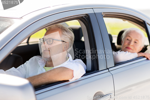 Image of happy senior couple driving in car