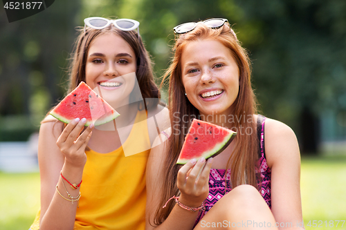 Image of teenage girls eating watermelon at picnic in park