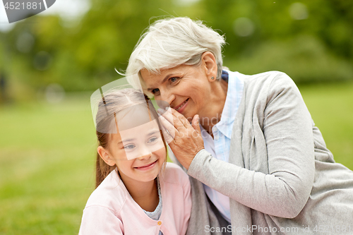 Image of granddaughter sharing secrets with grandmother