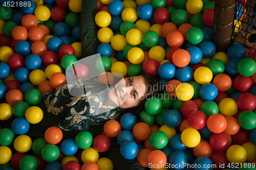 Image of Young mom with her kids in a children\'s playroom