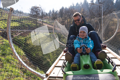 Image of father and son enjoys driving on alpine coaster