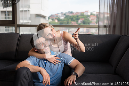 Image of young handsome couple hugging on the sofa