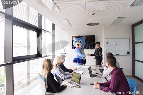 Image of boss dresed as bear having fun with business people in trendy of