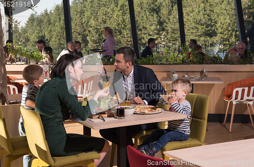 Image of Young parents enjoying lunch time with their children