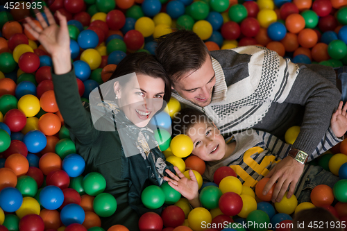 Image of young parents with kids in a children\'s playroom