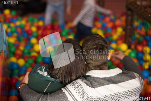 Image of young parents with kids in a children\'s playroom