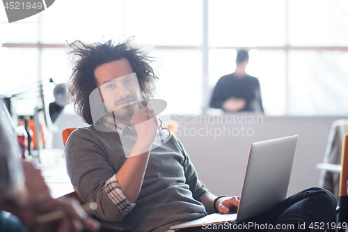 Image of businessman working using a laptop in startup office