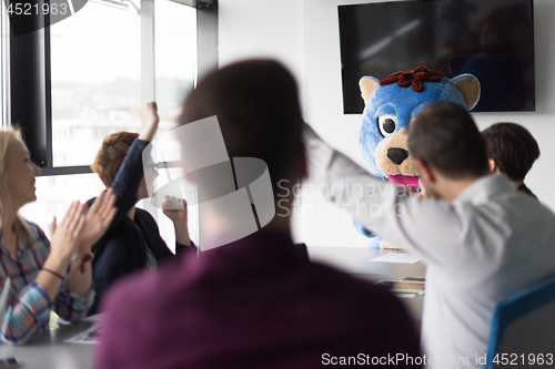 Image of boss dresed as bear having fun with business people in trendy of