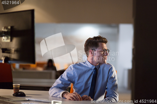 Image of man working on computer in dark office