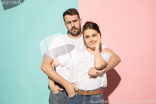 Image of Wow. Doubtful pensive couple with thoughtful expression making choice against pink background