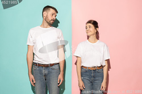 Image of Let me think. Doubtful pensive couple with thoughtful expression making choice against pink background