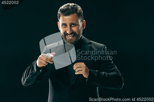 Image of The barded man in a suit at black studio