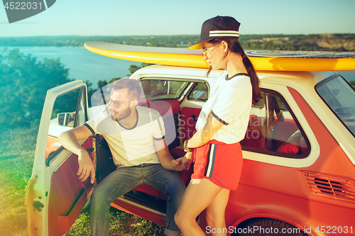 Image of Couple resting on the beach on a summer day near river