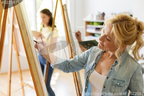 Image of woman with easel drawing at art school studio