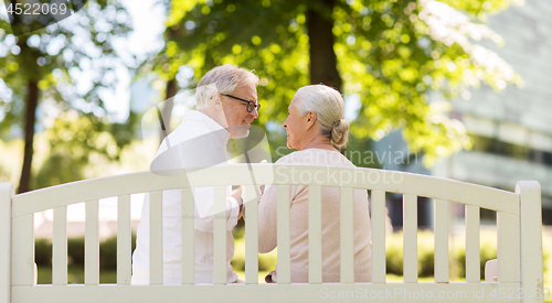 Image of happy senior couple sitting on park bench