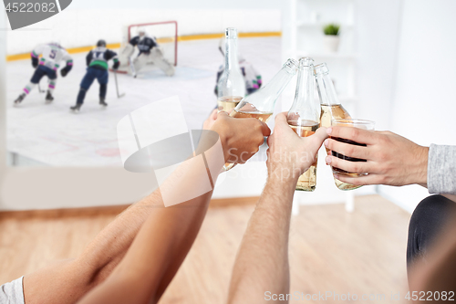 Image of friends watching ice hockey and drinking beer