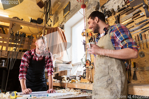 Image of carpenters with ruler and coffee at workshop