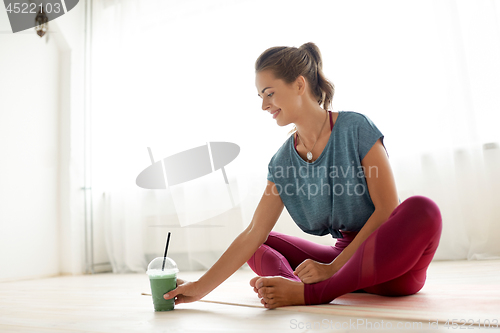 Image of woman with cup of smoothie at yoga studio